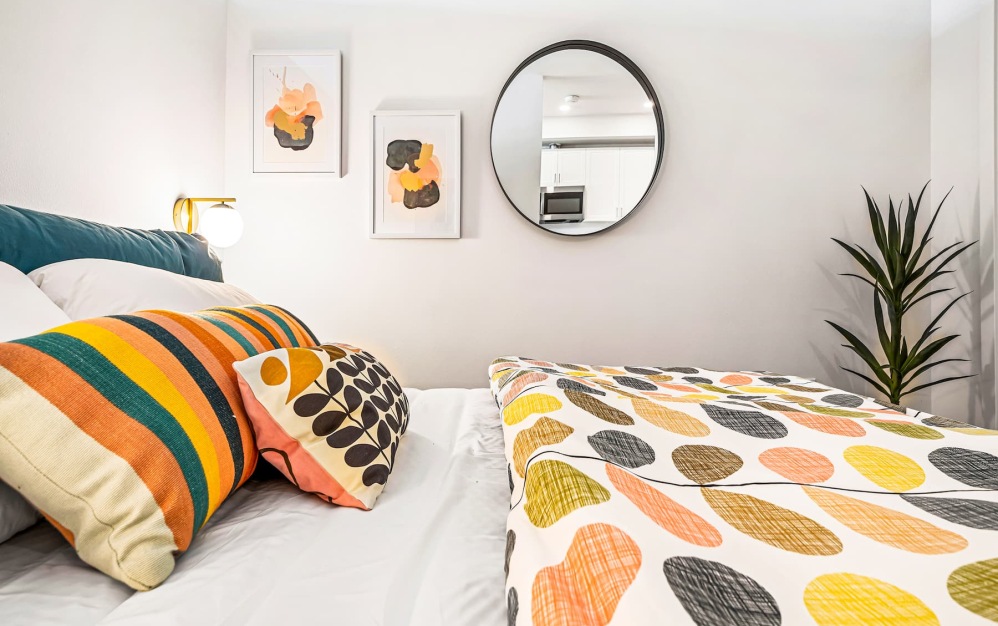bedroom with colorful bed spreads and a large closet