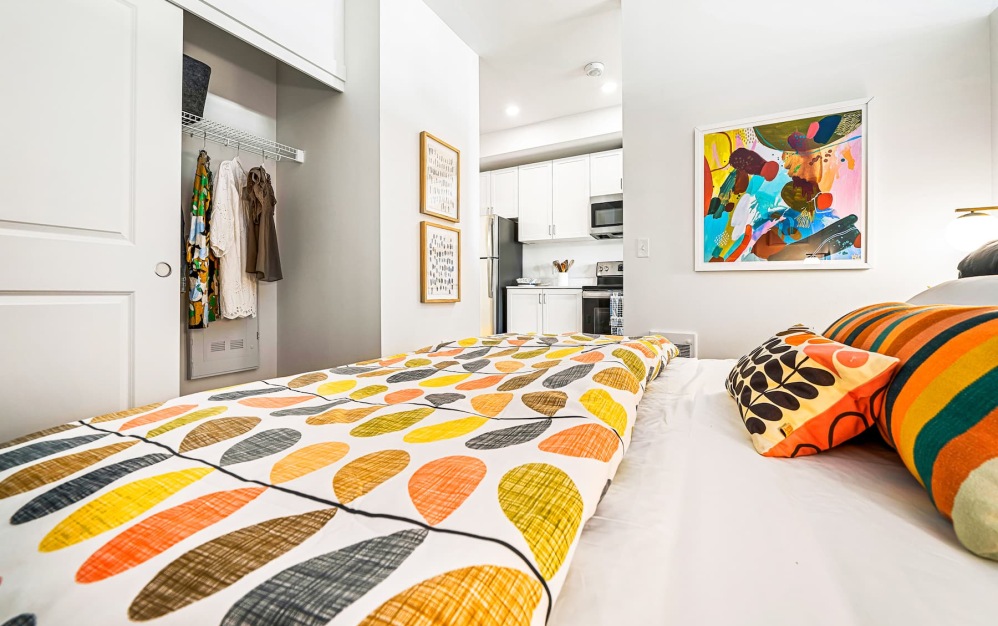 bedroom with colorful bed spreads and a large closet