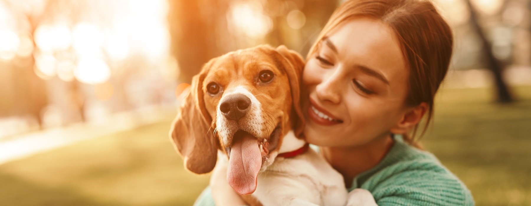 A woman and her dog sitting in a park.	